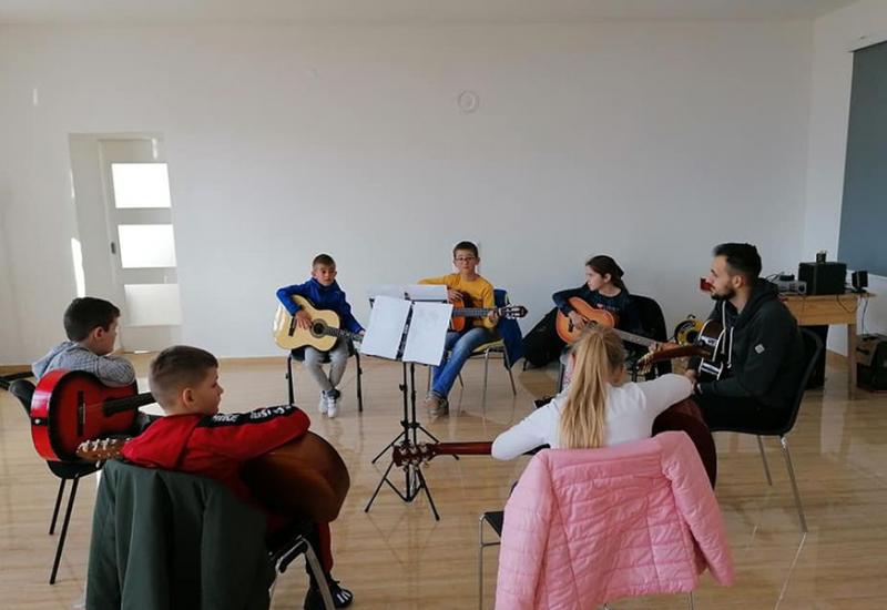 Djeca uče svirati gitaru - Udaljeni od grada, ali ne i od glazbe: Djeca u Rošku Polju pripremaju koncert